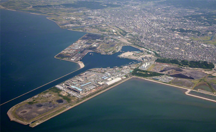 Aerial view of the Miike Port. The distinctive &quot;hummingbird&quot; form and design of the Miike Port was, and remains, a massive landform reaching out into the tidal channel of the eastern Ariake Sea. This long shape was necessary due to the tidal range of 5.5m and the consequent need to reach out into deeper water to facilitate shopping movements.