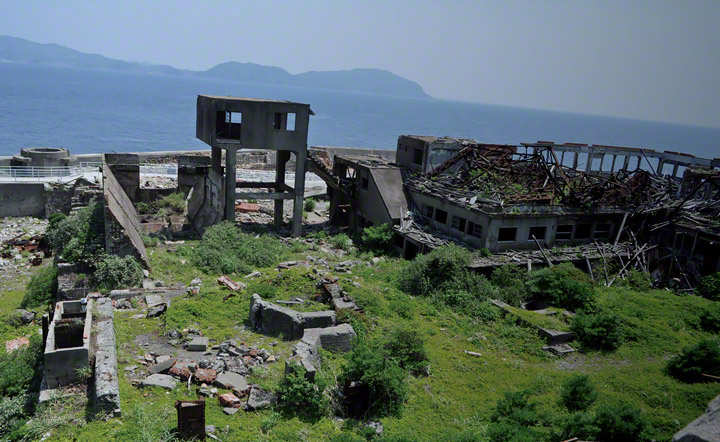 There are the remains of No. 2 shaft (left). Presently, only the round pit head, which was filled by concrete is visible. The tall building (center) was a bridge where miners entered into underground pits and check points. The building (light), which does not have a roof, was a management office.
