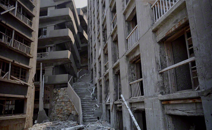 写真右は大正7年に建てられた16号棟。(別名：日給社宅)中央には16号棟に沿う形で作られた「地獄段」と呼ばれる生活用通路。その先には高台の端島神社まで続いていました。