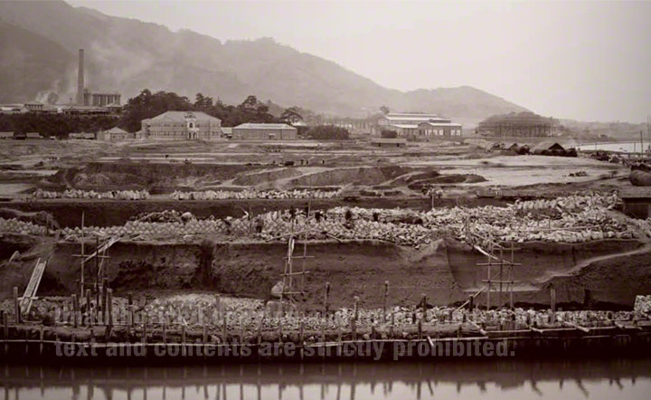 1898年建設途中の官営八幡製鐵所。本事務所（中央左）、鍛冶工場（右）、第一高炉（左上)。